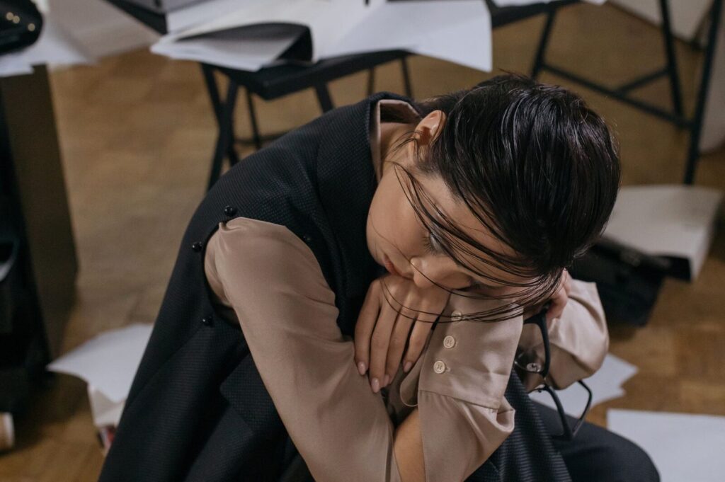 Femme au repos, tête posée sur le genou, fatigue chronique de la ménopause